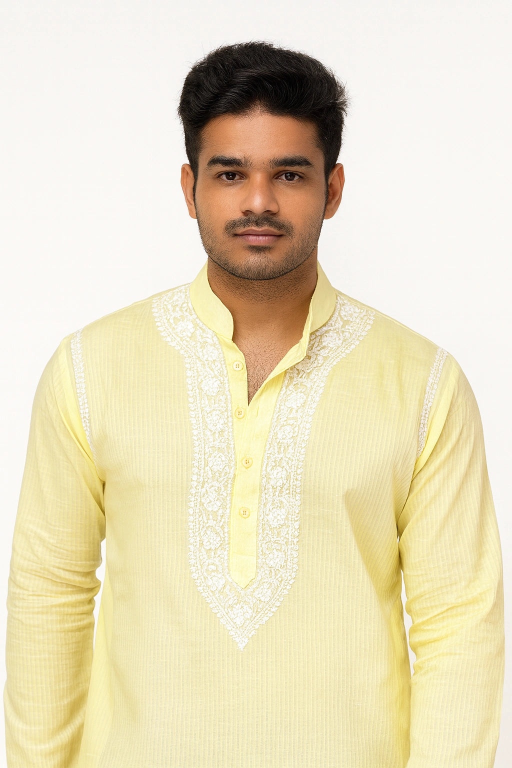 Man wearing a light yellow kurta with white embroidery on a white background