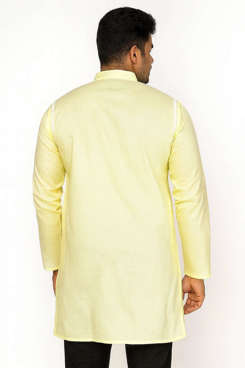 Man wearing a lucknowi chikankari light yellow kurta with black pants on a white background