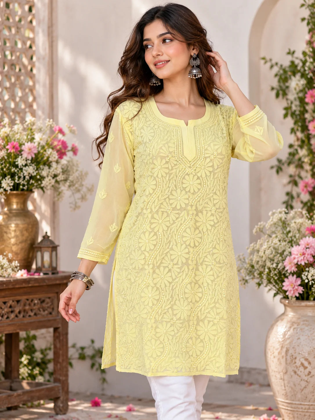 Woman wearing a lucknowi chikankari  yellow kurta with white floral patterns 