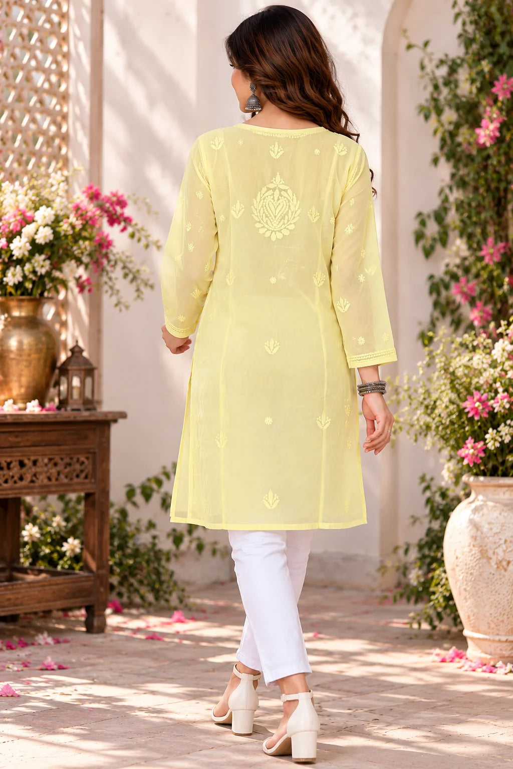 Woman wearing a lucknowi chikankari yellow-colored kurta with white floral patterns