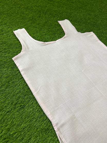 Slip with a wide scoop neckline, laid flat on a vibrant green grass background.