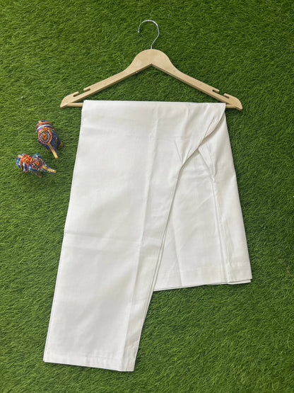 A white cotton men's pajama over a light wood hanger, set against a green artificial grass background with two small decorative bird figurines on the left.